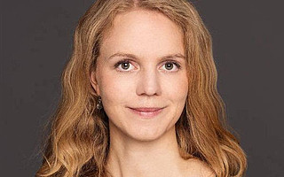 Portraitfoto von Lena Hoffmann vor dunklem Hintergrund