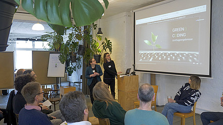 A photo from the industry workshop in Berlin. Elisabeth Schauermann (GI) and Carolin Henze (GI) are presenting the results from the survey. 