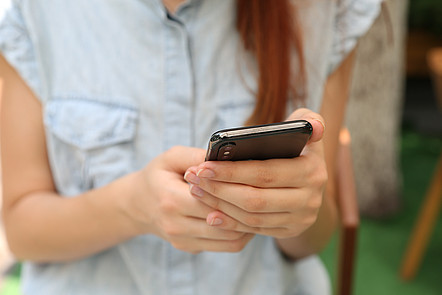 Eine Frau hält ein Smartphone in ihren Händen