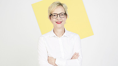 Porträt von Christine Regitz, sie lächelt und hat die Arme locker verschränkt
