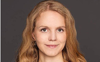 Portraitfoto von Lena Hoffmann vor dunklem Hintergrund
